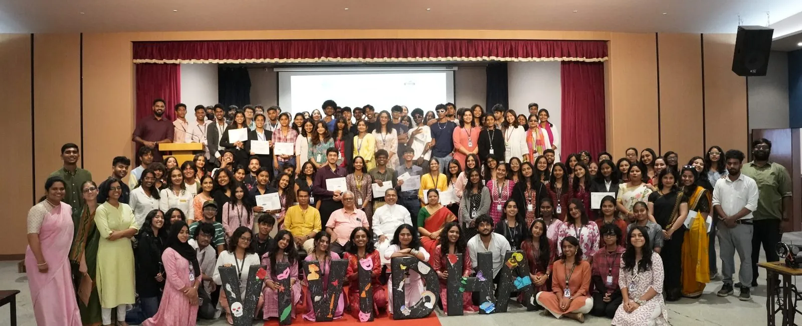 Students and faculty group photo in the auditorium